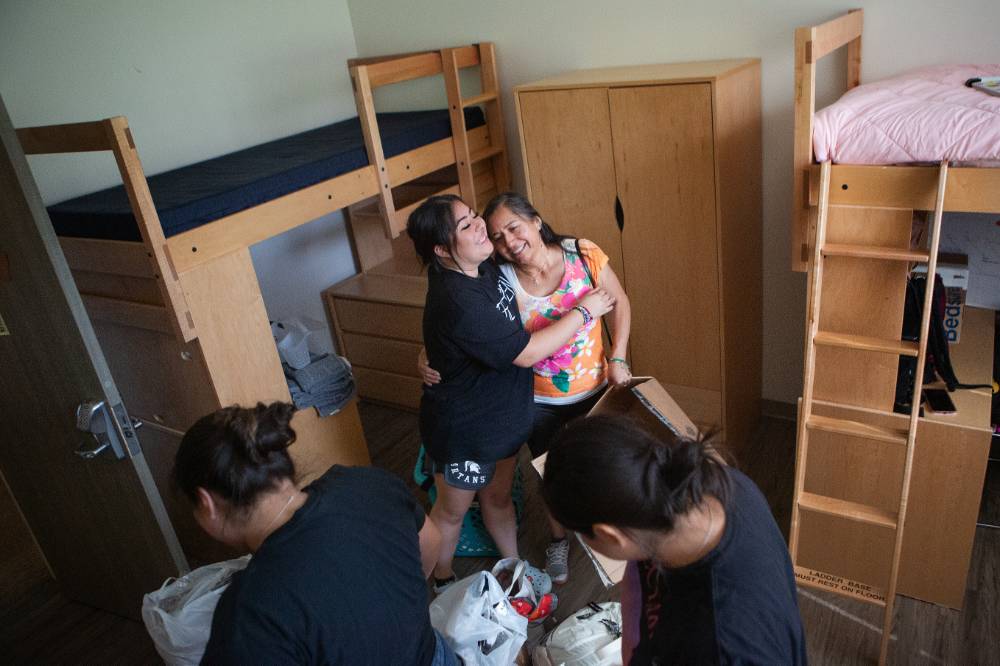 family members hugging while moving into the dorm.